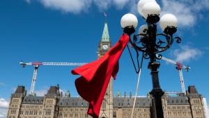 A red dress is hangs on a light fixture on National Day of Awareness for the prevention of violence against Indigenous women, also known as the Red Dress Day in Ottawa, Friday, May 5, 2023. THE CANADIAN PRESS/Spencer Colby