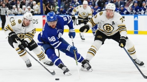 Toronto Maple Leafs' William Nylander (88) moves the puck between Boston Bruins' Parker Wotherspoon (29) and Charlie McAvoy (73) during second period action in Game 6 of an NHL hockey Stanley Cup first-round playoff series in Toronto on Thursday, May 2, 2024. THE CANADIAN PRESS/Nathan Denette