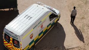 FILE - In this photo taken Tuesday, May 19, 2020, an ambulance passes a pedestrian in Khayelitsha in Cape Town South Africa. (AP Photo/Nardus Engelbrecht)