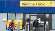 People walk past a vaccine clinic during the COVID-19 pandemic in Mississauga, Ont., on Wednesday, April 13, 2022. THE CANADIAN PRESS/Nathan Denette
