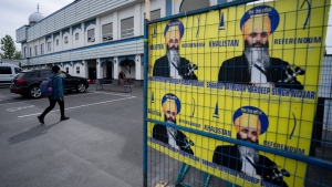 A person walks past signs showing Hardeep Singh Nijjar at the Guru Nanak Sikh Gurdwara in Surrey, B.C., on Friday, May 3, 2024. THE CANADIAN PRESS/Ethan Cairns