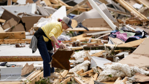 Valerie Bernhardt looks through debris at her stormed damaged home Thursday, May 9, 2024, in Columbia, Tenn.  (AP Photo/George Walker IV)