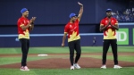 Canadian cricket team captain Saad Bin Zafar waves as he's flanked by teammates Nicholas Kirton, left, and Jeremy Gordon, right, after throwing out the first pitch at the Toronto Blue Jays game against the Minnesota Twins in Toronto on Friday, May 10, 2024. THE CANADIAN PRESS/Cole Burston