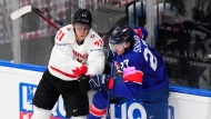 Canada's Kaiden Guhle, left, collides with Britain's Cole Shudra during the preliminary round match between Great Britain and Canada at the Ice Hockey World Championships in Prague, Czech Republic, Saturday, May 11, 2024. (AP Photo/Petr David Josek)