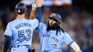Toronto Blue Jays first base Vladimir Guerrero Jr. (27) celebrates with first base coach Mark Budzinski (53) after hitting a two-run single during sixth inning MLB baseball action against the Minnesota Twins, in Toronto, Saturday, May 11, 2024. THE CANADIAN PRESS/Chris Katsarov 
