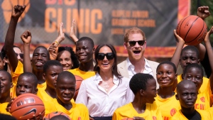 Prince Harry and Meghan, center, pose for a photograph with children during the Giant of Africa Foundation at the Dream Big Basketball clinic in Lagos Nigeria, Sunday, May 12, 2024.  (AP Photo/Sunday Alamba)