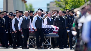 The casket of Santaquin Police Sgt. Bill Hooser is carried from Utah Valley University Monday, May 13, 2024, in Orem, Utah. Hooser was killed on May 5, 2024, while helping a Utah Highway Patrol trooper with a traffic stop when police say a man driving a semi-trailer intentionally hit Hooser. (AP Photo/Rick Bowmer)