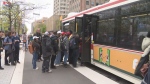 Commuters are shown boarding a shuttle bus outside St. George Station on May 13.