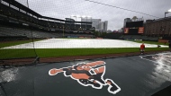 The tarp covers the field as the baseball game between the Baltimore Orioles and the Toronto Blue Jays was postponed due to weather, Tuesday, May 14, 2024, in Baltimore. The game will be made up as part of a traditional doubleheader on Monday, July 29. (AP Photo/Nick Wass)