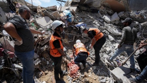 Palestinians rescuers dig around the body of man in the rubble of a building destroyed in an Israeli airstrike in Nuseirat, Gaza Strip, Tuesday, May 14, 2024. (AP Photo/Abdel Kareem Hana) 