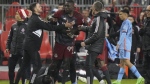 Toronto FC forward Prince Owusu (99) is restrained by team staff members after MLS action against New York City FC in Toronto, Saturday, May 11, 2024. Toronto FC will be missing its coach and five players through suspension for Wednesday's game at Nashville SC after the MLS Disciplinary Committee handed down its initial verdict on Saturday night's ugly post-game melee with New York City FC. THE CANADIAN PRESS/Frank Gunn