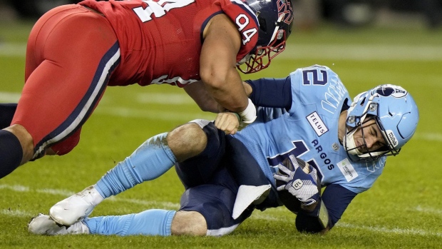 Montreal Alouettes defensive lineman Mustafa Johnson (94) tackles Toronto Argonauts quarterback Chad Kelly (12) during second half CFL Eastern Division final football action in Toronto, Saturday, Nov. 11, 2023. Kelly, who is under a league suspension, is not currently participating in team activities at training camp. THE CANADIAN PRESS/Frank Gunn