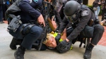 Police wrestle a pro-Palestinian protester to the ground to put wrist restraints on him at the University of California, Irvine, after police began to move protesters and an encampment off the quad in Irvine, Calif. on Wednesday, May 15, 2024. (Leonard Ortiz/The Orange County Register via AP)