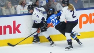 Minnesota's Claire Butorac (7) and Lee Stecklein (2) battle for the puck with Toronto's Emma Maltais (27) during first period Game 5 playoff PWHL action in Toronto, Friday, May 17, 2024. THE CANADIAN PRESS/Mark Blinch 