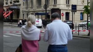 Tourists watch the entrance of the Harry Winston jewelry after a robbery in Paris, Saturday, May 18, 2024. French police investigators were hunting Saturday for armed robbers on motorbikes who hit a jewelry store on one of Paris' poshest streets, and media reports said the target was the exclusive Harry Winston boutique, self-described "Jeweler to the Stars." (AP Photo/Thibault Camus)