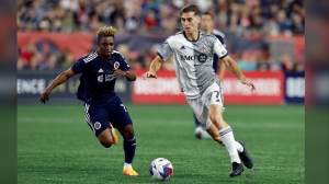 Toronto FC's Jordan Perruzza (77) and New England Revolution's Latif Blessing (19) compete during the second half of an MLS soccer match, in Foxborough, Mass., Saturday, June 24, 2023. THE CANADIAN PRESS/AP-Michael Dwyer