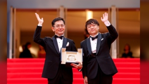 Goro Miyazaki, left, and Kenichi Yoda pose for photographers with the Studio Ghibli honorary Palme d'Or upon arrival at the premiere of the film 'The Apprentice' at the 77th international film festival, Cannes, southern France, Monday, May 20, 2024. (Photo by Vianney Le Caer/Invision/AP)