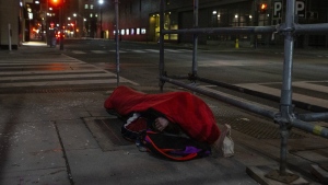 A man sleeps on the street in Toronto on Friday, March 11, 2022. A new report says the number of older adults who are homeless is growing and shelters are not designed to meet their physical or mental health needs. THE CANADIAN PRESS/Chris Young