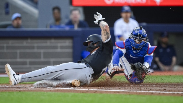 Chicago White Sox's Korey Lee (26) slides in to home ahead of the tag from Toronto Blue Jays catcher Danny Jansen (9) attempts to make a tag during second inning MLB baseball action in Toronto on Tuesday, May 21, 2024. THE CANADIAN PRESS/Christopher Katsarov