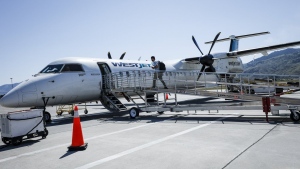 WestJet Airlines has plans to soon introduce a new cheaper fare category that would be available to travellers willing to fly without a carry-on bag. A passenger boards a WestJet Encore Bombardier Q400 twin-engined turboprop aircraft in Kamloops, B.C., Saturday, June 3, 2023. THE CANADIAN PRESS/Jeff McIntosh