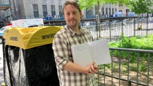 Richard Partington poses for a photo while holding up a line list outside Manhattan Criminal Court, Friday, May 24, 2024, in New York. A handful of people, including 43-year-old Partington of East Hampton, N.Y., were already lined up Friday for the chance to witness closing arguments on Tuesday. (AP Photo/Karen Matthews)