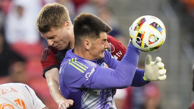Toronto FC's Sigurd Rosted (back) collides with FC Cincinnati goalkeeper Roman Celentano during first half MLS soccer action in Toronto on Saturday, May 25, 2024. THE CANADIAN PRESS/Frank Gunn