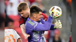 Toronto FC's Sigurd Rosted (back) collides with FC Cincinnati goalkeeper Roman Celentano during first half MLS soccer action in Toronto on Saturday, May 25, 2024. THE CANADIAN PRESS/Frank Gunn
