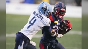 Montreal Alouettes running back Jeshrun Antwi (20) tries to rush past Toronto Argonauts defensive back Tarvarus McFadden (4) during first half pre-season CFL football action in Montreal, Saturday, May 25, 2024. THE CANADIAN PRESS/Christinne Muschi