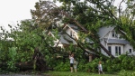 Max Comer and his sons, Finnegan, 9, and McCoy, 5, view storm damage to their next door neighbor's home, Sunday, May 26, 2024, in Claremore, Okla. (Mike Simons/Tulsa World via AP)
