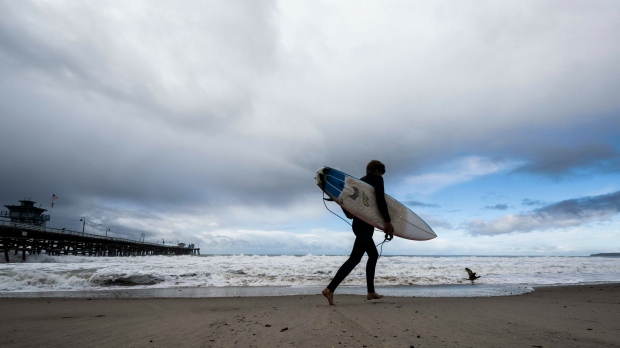  A surfer heads to the water as storms move through the area in San Clemente, Calif., Dec. 12, 2022. (Paul Bersebach/The Orange County Register via AP, File)