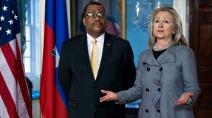 In this file photo, former Secretary of State Hillary Rodham Clinton, accompanied by former Haitian Prime Minister Garry Conille speaks at the State Department in Washington, Wednesday, Feb. 8, 2012. (AP Photo/Manuel Balce Ceneta