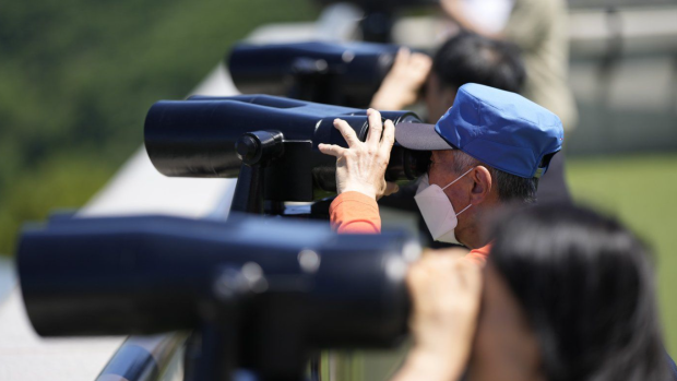 Visitors use binoculars to see the North Korean side from the unification observatory in Paju, South Korea, Tuesday, May 28, 2024. (AP Photo/Lee Jin-man)