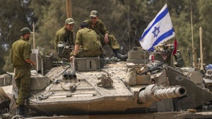Israeli soldiers work on a tank near the Israeli-Gaza border, in southern Israel, Wednesday, May 29, 2024. (Tsafrir Abayov/AP Photo)