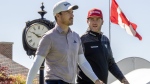 Canadians Nick Taylor (left) and Taylor Pendrith walk down the fairway after their tee shots on the 1st hole in the first round of the Canadian Open in Hamilton on Thursday, May 30, 2024. THE CANADIAN PRESS/Frank Gunn