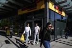Customers walk out with their shopping from a new "small format" No Frills grocery store, which the company is testing, in Toronto, Thursday, May 30, 2024. THE CANADIAN PRESS/Chris Young