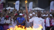 FILE - Torchbearer Didier Drogba of France holds the torch to light the cauldron at the Velodrome stadium in Marseille, southern France, Thursday, May 9, 2024. THE CANADIAN PRESS/AP-Daniel Cole