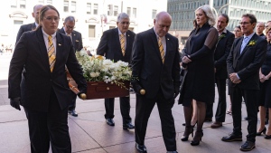 Julie-Anne Saumur, right, flanked by her family watch as the urn containing the ashes of her husband, Quebec singer Jean-Pierre Ferland arrives for his national funeral at Mary Queen of the World Cathedral in Montreal, Saturday, June 1, 2024. THE CANADIAN PRESS/Christinne Muschi
