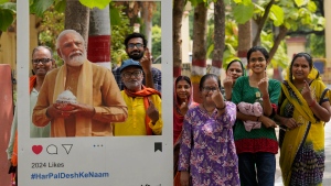 A group of people show their index fingers marked with an indelible ink as they pose for a photograph next to a cutout portrait of Indian Prime Minister Narendra Modi after casting their vote in the seventh and final phase of India's national elections, in Varanasi, India, Saturday, June 1, 2024. (AP Photo/Rajesh Kumar Singh) 
