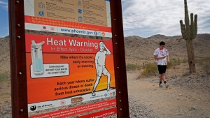 A hiker finishes his morning walk at the South Mountain Preserve to beat the high temperatures, Thursday, July 11, 2019, in Phoenix. An excessive heat warning is in effect for the Phoenix area with temperatures expected to hit 113. (AP Photo/Matt York)