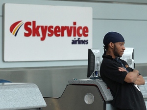 A worker at Pearson International Airport in Toronto stands in front of Skyservice Airlines' check-in counter Wednesday, March 31, 2010. (THE CANADIAN PRESS/Darren Calabrese)