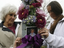 Doreen Graichen (left) and Randi Millen, Victoria (Tori) Stafford's grandmother and aunt, tie a new bouquet of flowers with a photo of Tori to a pole at Millen's home in Woodstock, Ont., Wednesday, April 7, 2010. (THE CANADIAN PRESS/Dave Chidley)