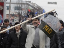 A Kyrgyz protester holds a captured police shield during clashes with police in Bishkek, Kyrgyzstan, Wednesday, April 7, 2010. (AP Photo/Ivan Sekretarev)