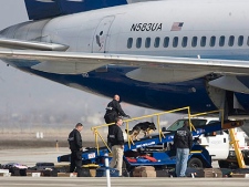 A United Airlines plane is searched at Salt Lake City International Airport and has its luggage removed after being diverted while on a flight from Denver to San Francisco and forced to land in Salt Lake City due to a bomb threat, Thursday Feb. 18, 2010 . (AP Photo/Deseret News, Laura Seitz)
