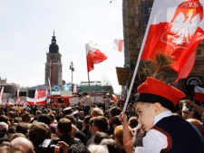 A boy wearing traditional cloth from the Krakow region attends a mass outside Mariacki church on Sunday, April 18, 2010 in Krakow, southern Poland.