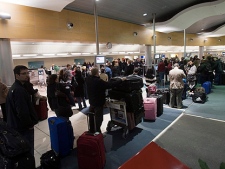 Passengers wait to check-in at midnite at the airport Sunday, April 18, 2010 in St. John's N.L.. Most flights on Monday have been cancelled after reports the volcanic ash cloud may be heading toward Newfoundland. (THE CANADIAN PRESS/Ryan Remiorz)