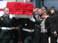Fred McKay, his wife Beth and son Riley, to the right of the frame, the family of Pte. Kevin McKay, watch tearfully as the casket carrying the remains of their son and brother is brought to a waiting hearse at CFB Trenton, Sunday May 16, 2010, during a repatriation ceremony on the tarmac at the military base.