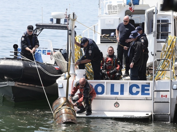 Police remove a barrel believed to be containing a body encased in concrete from the Toronto harbour on Sunday, May 23, 2010. 