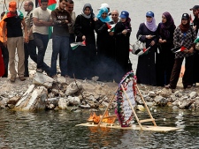Palestinians look at a floating memorial sign during a protest against the Israeli naval commando raid on a flotilla attempting to break the blockade on Gaza, at the port in Gaza City, Tuesday, June 1, 2010. Palestinians in Gaza declared a general strike and a day of wrath following Israel's deadly naval raid on an aid flotilla bound for the blockaded Gaza Strip on Monday.(AP Photo/Hatem Moussa)