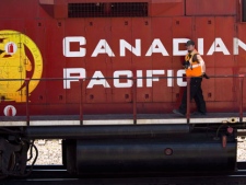 A Canadian Pacific Railway employee walks along the side of a locomotive in a marshalling yard in Calgary, Wednesday, May 16, 2012. Unionized workers at Canadian Pacific Railway (TSX:CP) have turned up the heat at the bargaining table, serving 72 hour strike notice.THE CANADIAN PRESS/Jeff McIntosh