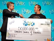 Rod Phillips (left), OLG�s President and CEO, presents Timothy Schell with his $50-million winning Lotto Max lottery cheque in Toronto on Tuesday, May 22, 2012. (THE CANADIAN PRESS/HO-Ontario Lottery and Gaming Corporation)